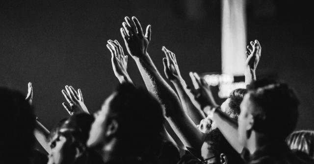 Grayscale photo of people raising their hands 1666816